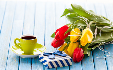 Cup and gift box with bouquet of tulips