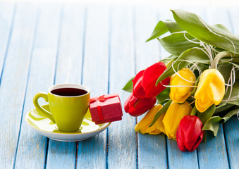 Cup and gift box with bouquet of tulips