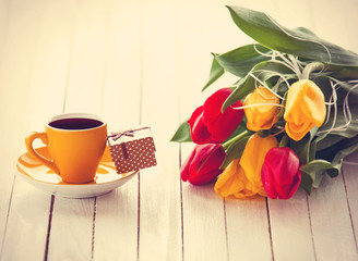 Cup and gift box with bouquet of tulips