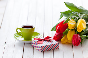 Cup and gift box with bouquet of tulips