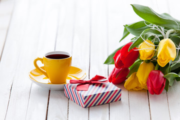 Cup and gift box with bouquet of tulips