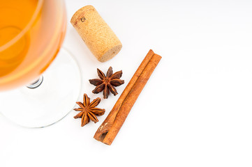 Wine glass, cork and cinnamon on white background