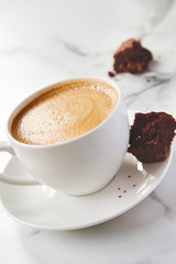 Angled view of cappuccino or latte coffee with chocolate brownie
