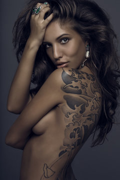 Sensual brunette woman with tattoo