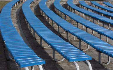 Row of blue wooden seats on a spectator grandstand photo.