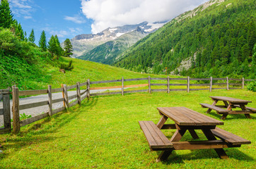 Wooden benches for visitors to picnic, beautiful Alps view
