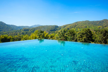 Fototapeta na wymiar Beautiful blue pool overlooking mountain landscape