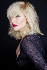 Portrait sexy blonde in studio, black background