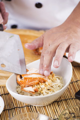 Chef putting roast chicken to bowl of Noodle