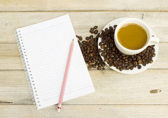 Book, pencils and coffee on a wooden table