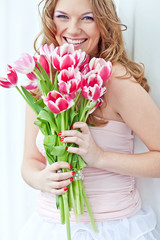 Happy woman with a bouquet of pink tulips