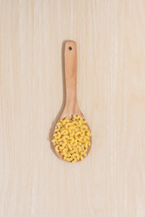 Macaroni on paddle with wooden background.