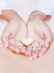 Obraz premium Girl holding wood shape of heart . Concept for giving love.