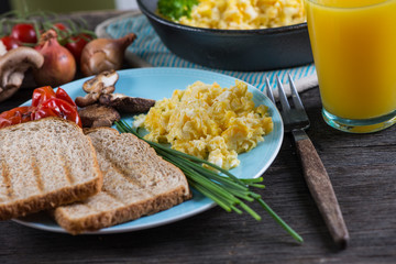 eating healthy breakfast, scrambled egg with chives and fresh ju