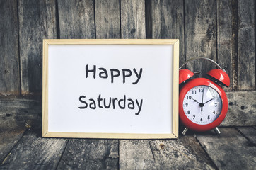 Happy Saturday message on white board and red retro clock  by wo