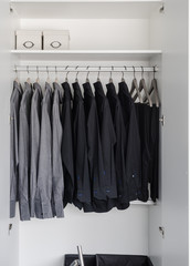 row of black and grey shirts hanging on coat hanger