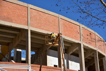 obrero trabajando sobre una grua