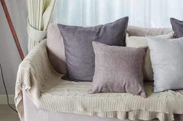 pillows and blanket on earth tone sofa in