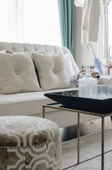 tray of glass on table with beige color sofa in living room