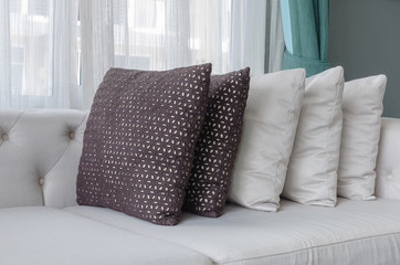 row of pillows on white modern sofa in living room