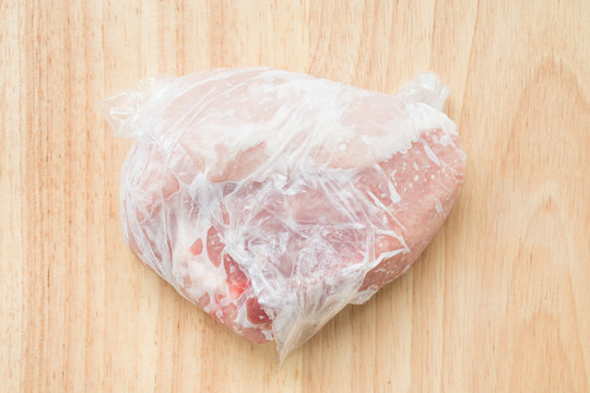 Frozen meat in plastic wrap inside