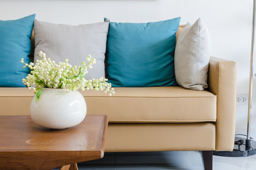 Fototapeta na wymiar plant in ceramic vase on wooden table with modern sofa