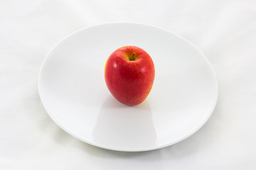 Red ripe apple on plate