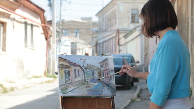 Young painter painting cityscape with watercolor