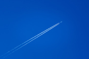Airplane In The Sky With Plane Trails - obrazy, fototapety, plakaty
