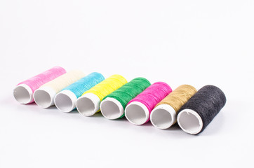 multicolor sewing threads on white background,