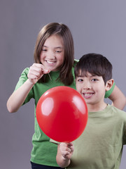 Popping her brother's balloon.