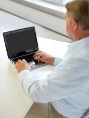 close up of senior man with laptop typing