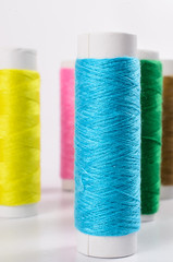 multicolor sewing threads on white background,
