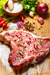 Close-up of fresh meat steak with spices on wooden background