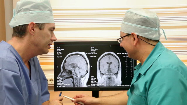 Two Doctors In Hospital Examining CT Scan