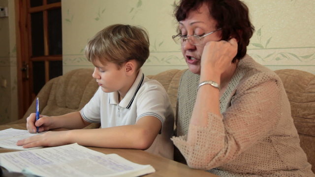 Grandma helping her grandson doing homework