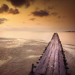 Obraz na płótnie Canvas Beautiful sunset over the tropical beach with old bridge