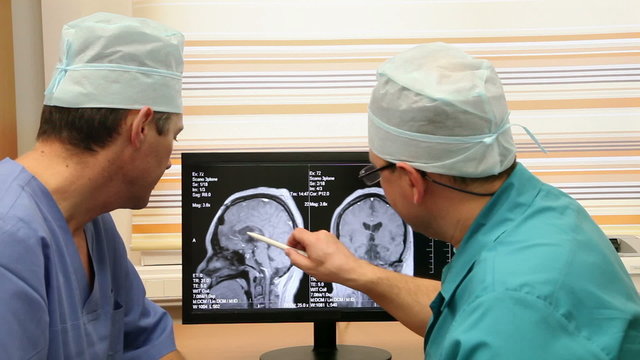 Two Mature Doctors In Hospital Examining CT Scan