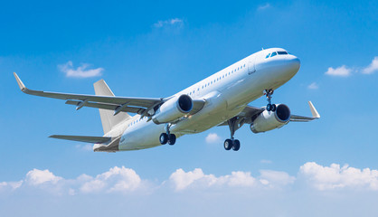 Fototapeta na wymiar Commercial plane taking off against blue sky