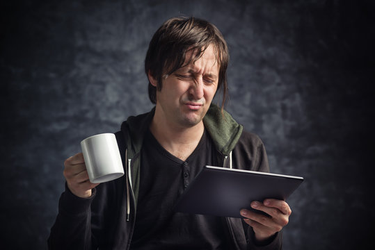 Man Reading Bad News on Digital Tablet Computer