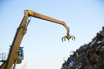 Crane grabber loading metal rusty scrap in the dock