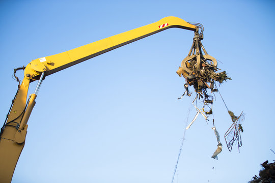 Crane grabber loading metal rusty scrap in the dock