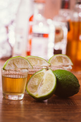 tequila , lime and salt on wooden table