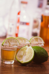 tequila , lime and salt on wooden table