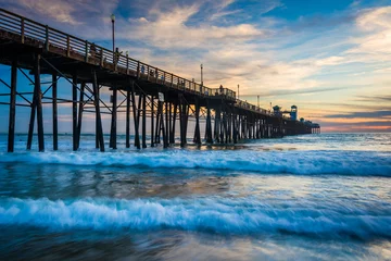 Deurstickers The pier and waves in the Pacific Ocean at sunset, in Oceanside, © jonbilous