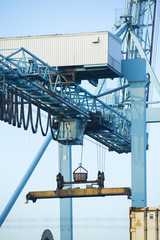 Shore crane loading containers in freight ship