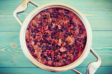 oatmeal, walnut and black currant casserole in pan on blue table