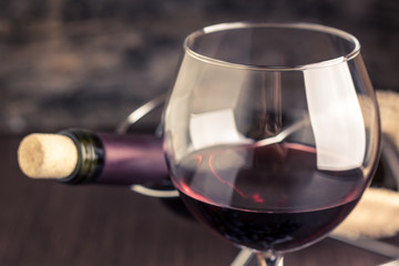 Red wine in wineglass against corked bottle