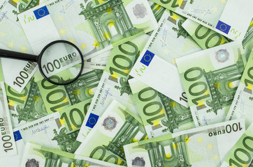 Magnifying glass on euro banknotes background