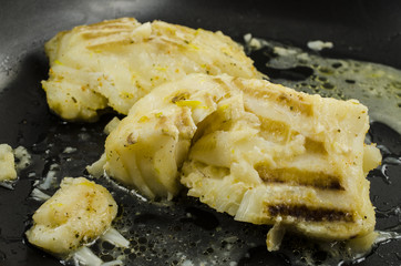 White cod on black frying pan